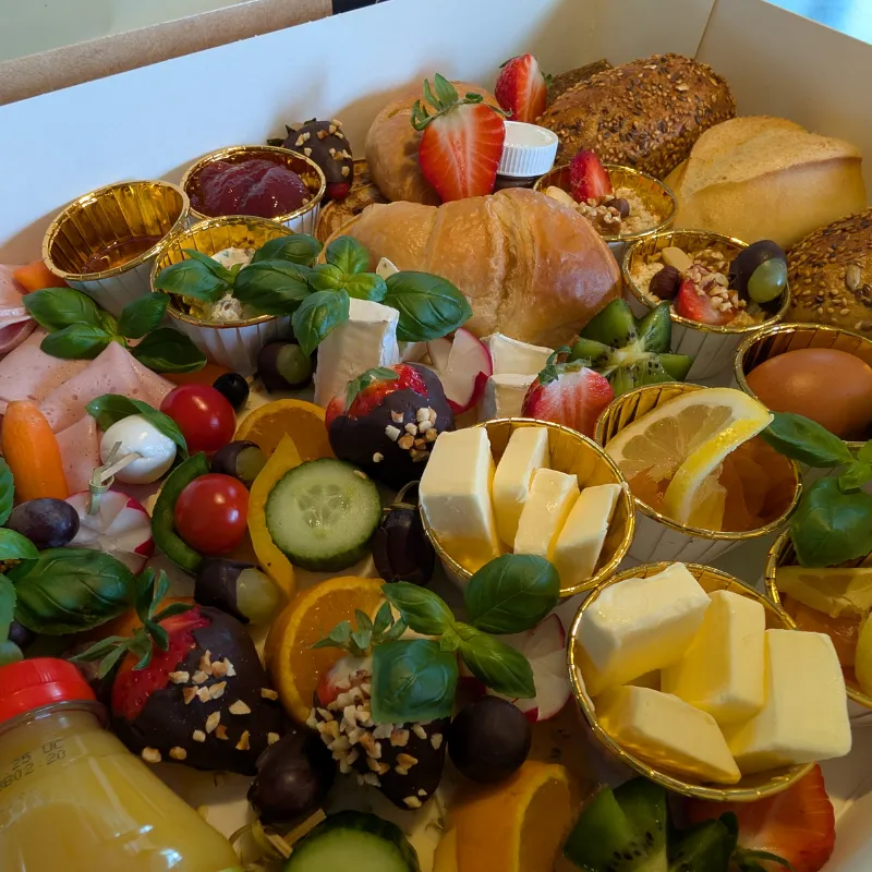 Frisches Obst, Gemüse und Tomate-Mozzarella-Spieße in einer Frühstücksbox