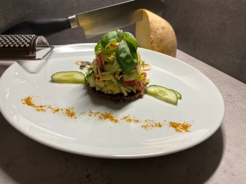 Kleine Brottaler mit frischer Vorspeisen-Garnitur auf weißem Teller